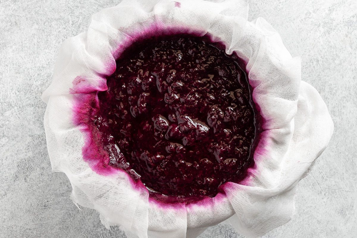 Taste of Home Blueberry Jelly Recipe photo of straining the blueberries through a cheese cloth.