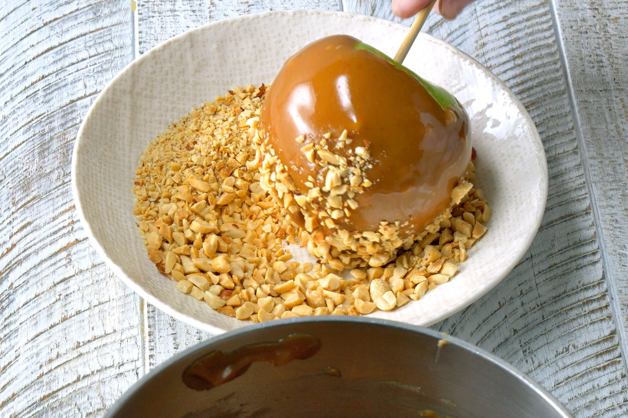 Roll bottoms of dipped apples into chopped peanuts