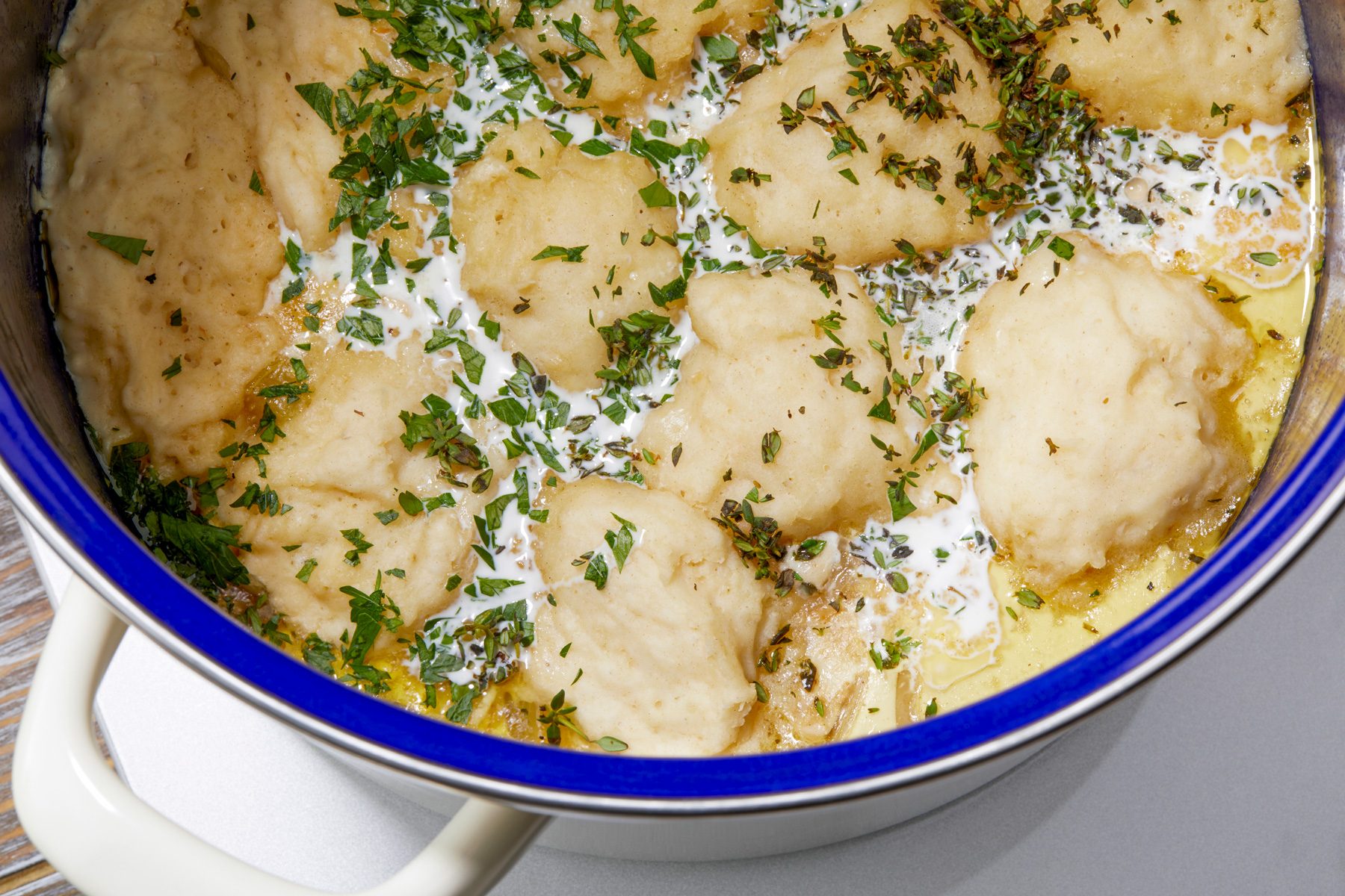 overhead shot; Gently stiring in cream, parsley and thyme; seasoned with salt and pepper