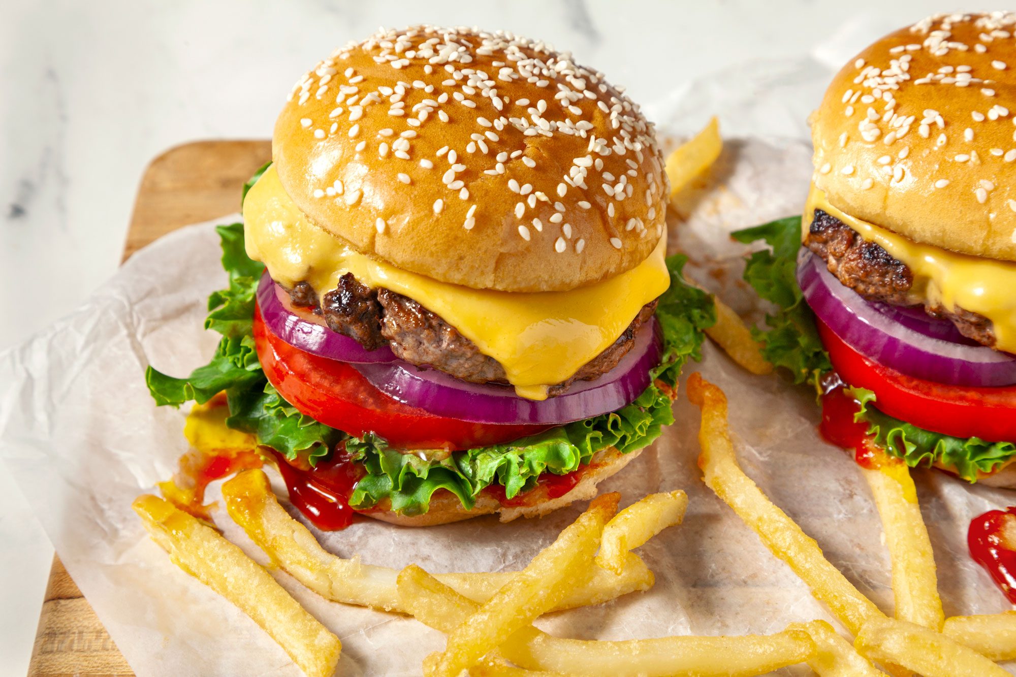 Two cheeseburgers served with French fries