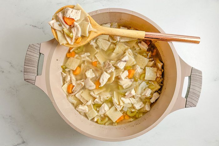 Taste of Home Copycat Cracker Barrel Chicken and Dumplings in a Dutch Oven on a marble surface