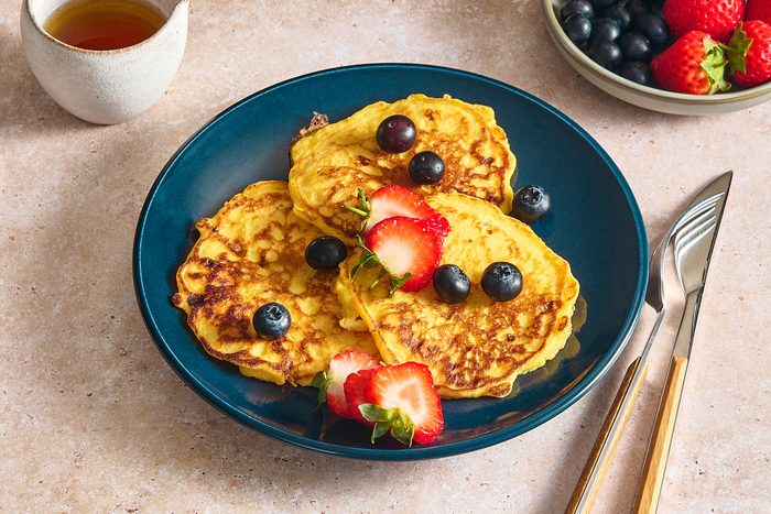 Angled shot of cottage cheese pancakes topped with berries