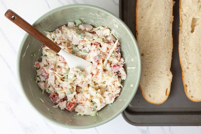 Step 1 of Taste of Home Crab Salad Sandwiches is to combine the mayonnaise, salt, and pepper. Stir in the crab, cheese, red pepper, onions and celery. Spoon over the bread halves.