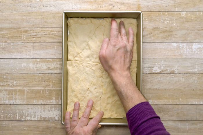 Dough rolled in the shape of a rectangle pressed onto the bottom of a baking pan.