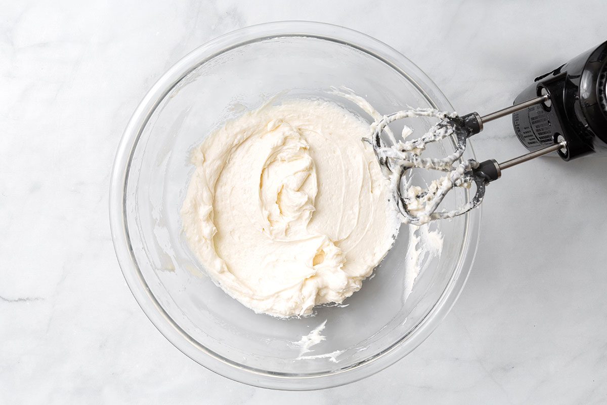Vanilla whipped filling in a mixing bowl for step two of Ho Ho Cake recipe for Taste of Home