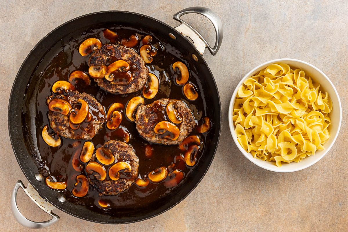 Taste of Home Old Fashioned Salisbury Steak recipe photo of the finished salisbury steaks with noodles.