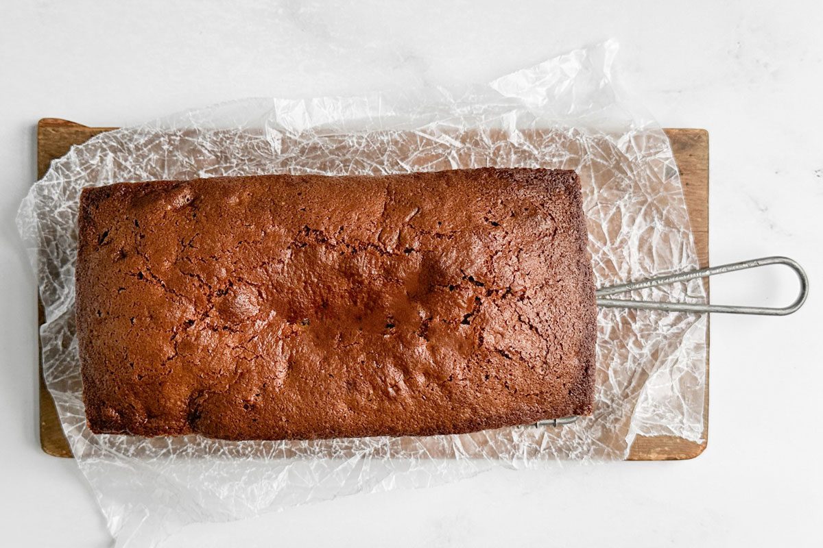 Taste of Home Peach Bread on a wire rack on a wooden board