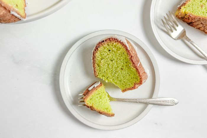 Taste of Home Pistachio Bundt Cake on white plates on a marble surface