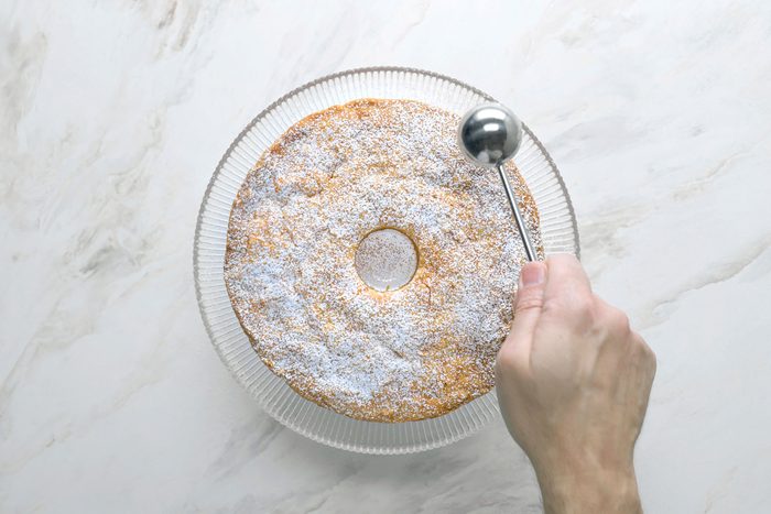 Sprinkling the cake with confectioners sugar