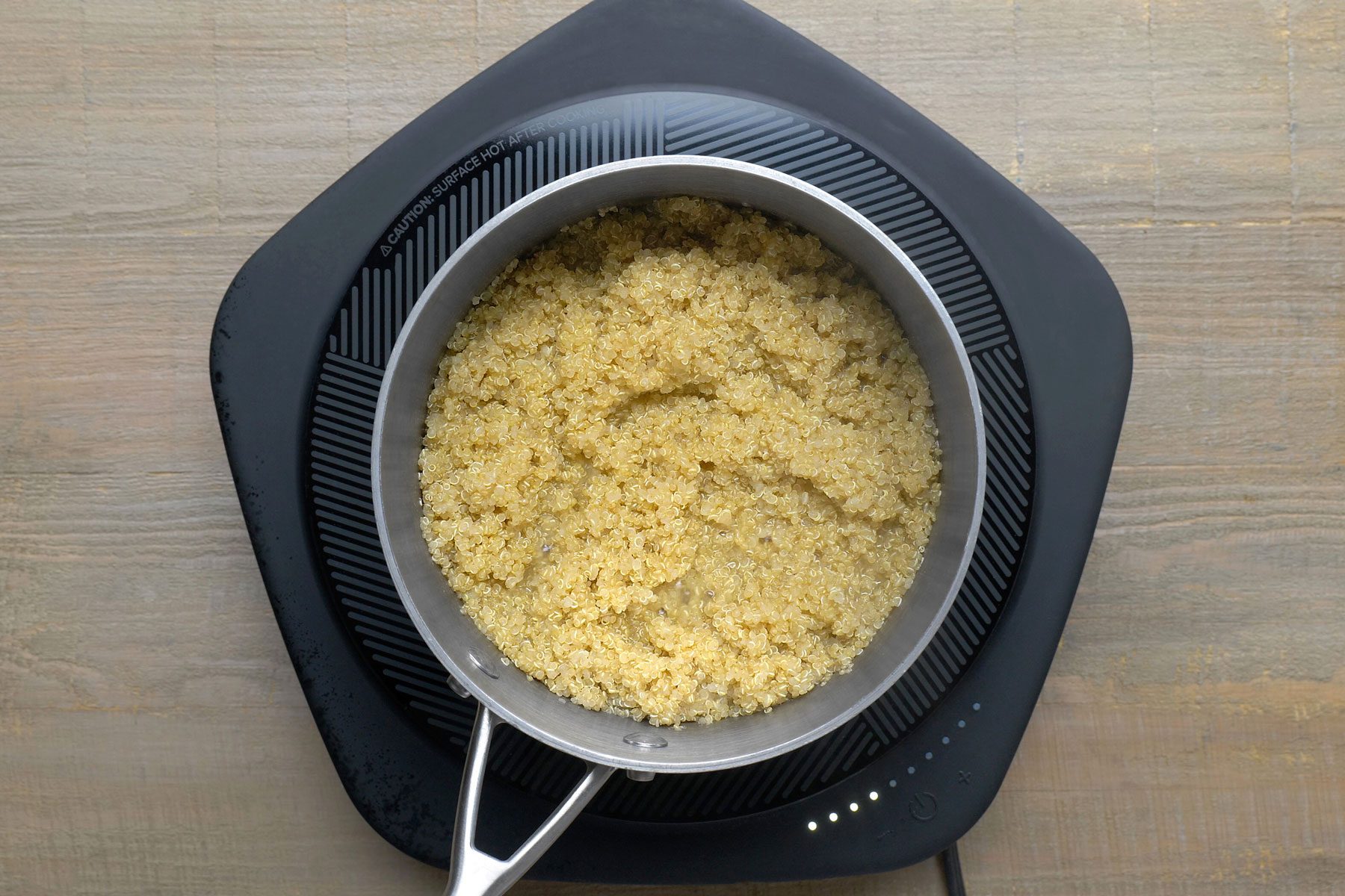 Quinoa simmering with water in a large saucepan.