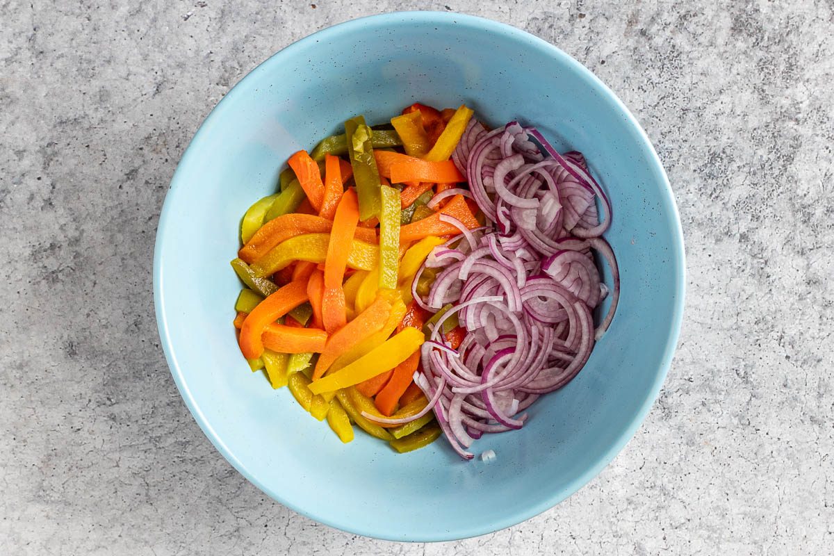 Taste of Home Roasted Pepper Salad photo of the roasted peppers and onion in a mixing bowl.