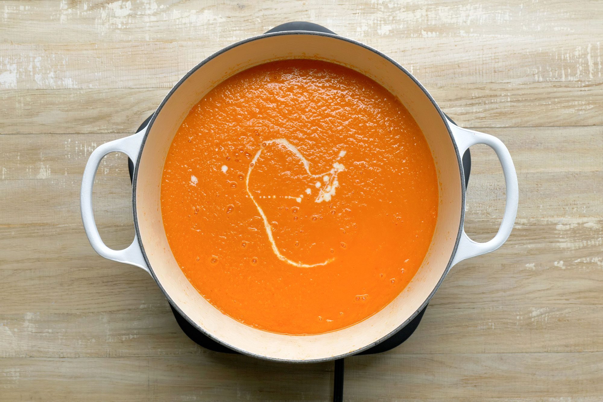 Roasted Tomato Soup in a pan; Wooden Background;