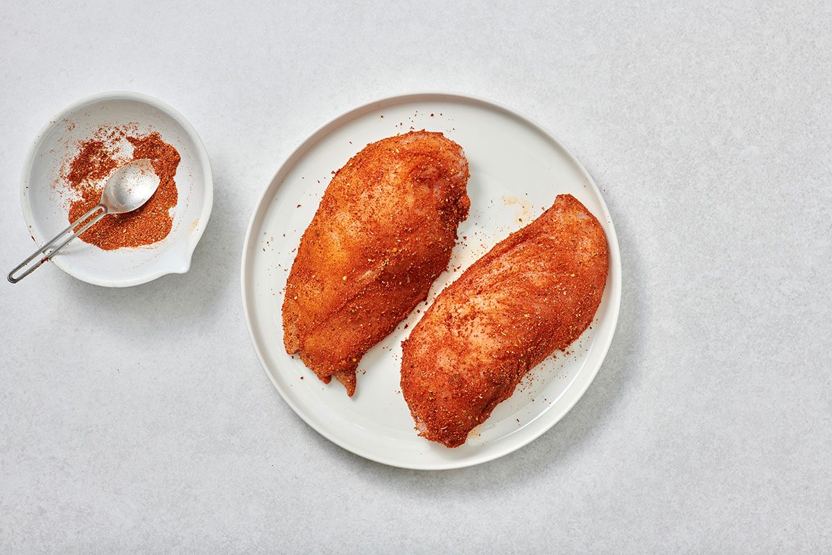 Chicken breast rubbed with taco seasoning on a plate 