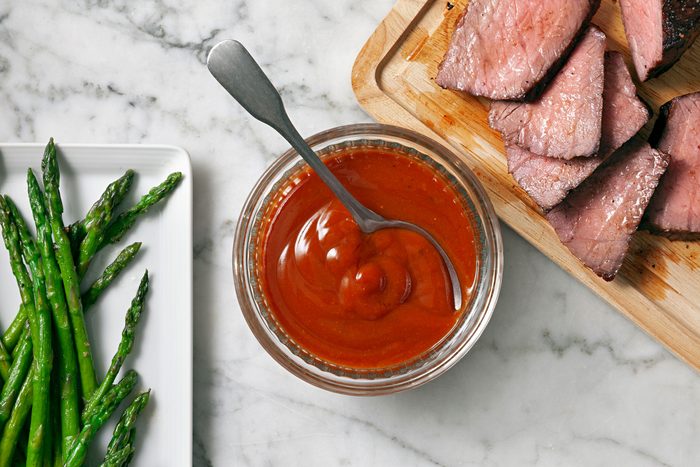 Steak Sauce with steak slices in one corner and vegetables on opposite corner.