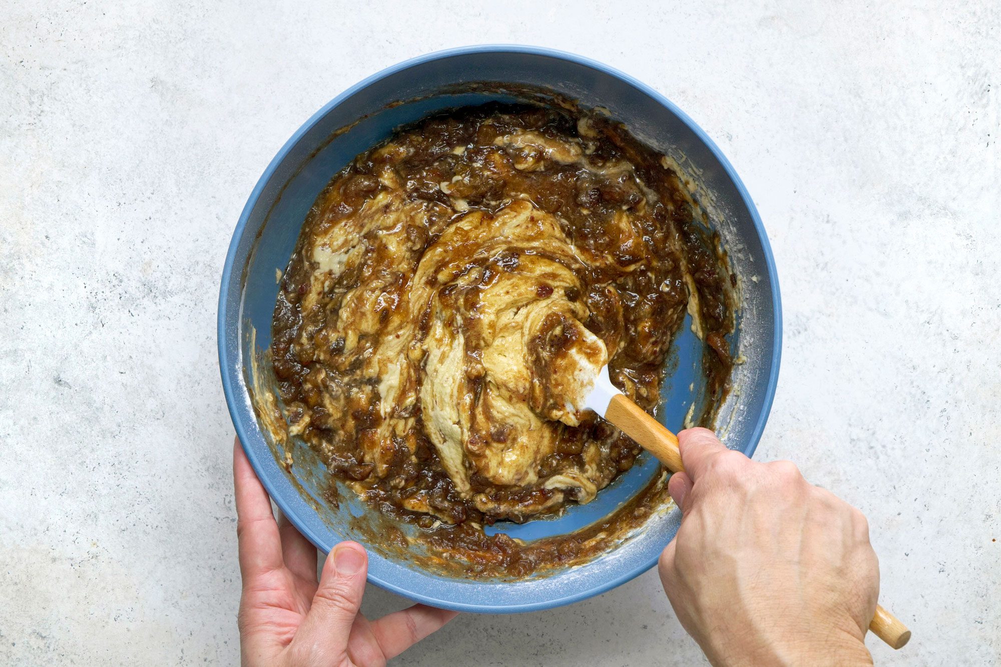 Overhead shot of gradually add to creamed mixture; stir in date mixture; spatula; marble surface;