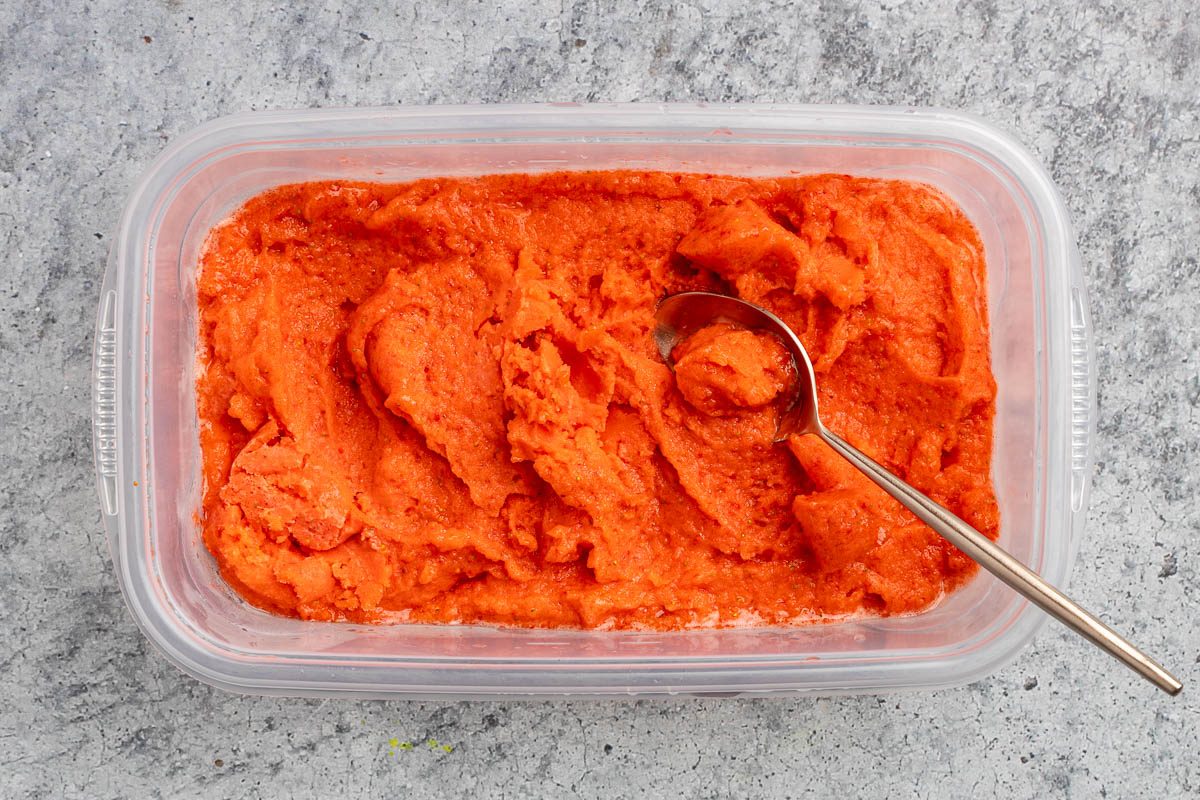 Taste of Home Strawberry Sorbet recipe photo of partially frozen sorbet in a freezer safe container.
