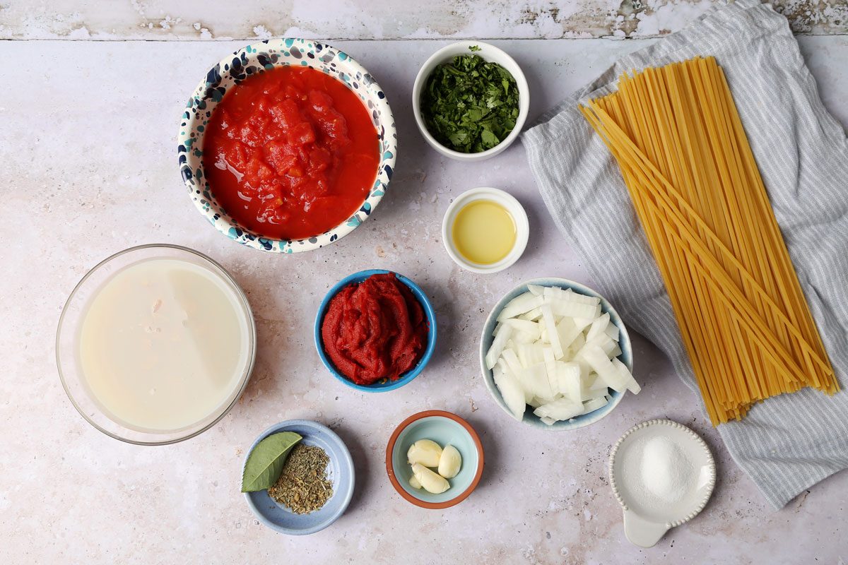 Ingredients for Taste of Home's Red Clam Sauce laid out in small bowls on a grey surface.