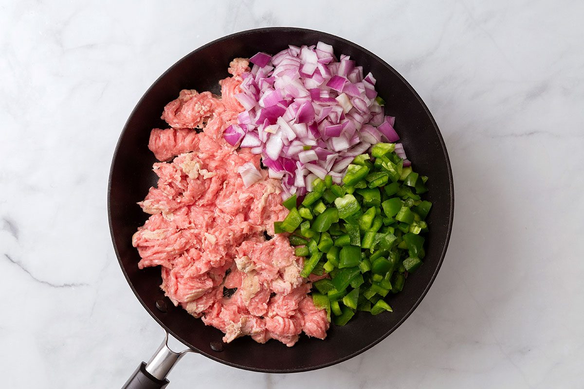 Lean ground turkey, chopped red onion and green pepper in a large skillet 