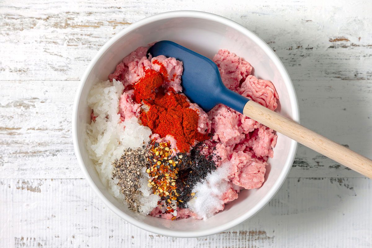 In A Large Bowl, Thoroughly Combine Lamb, Onion, Paprika, Red Pepper Flakes