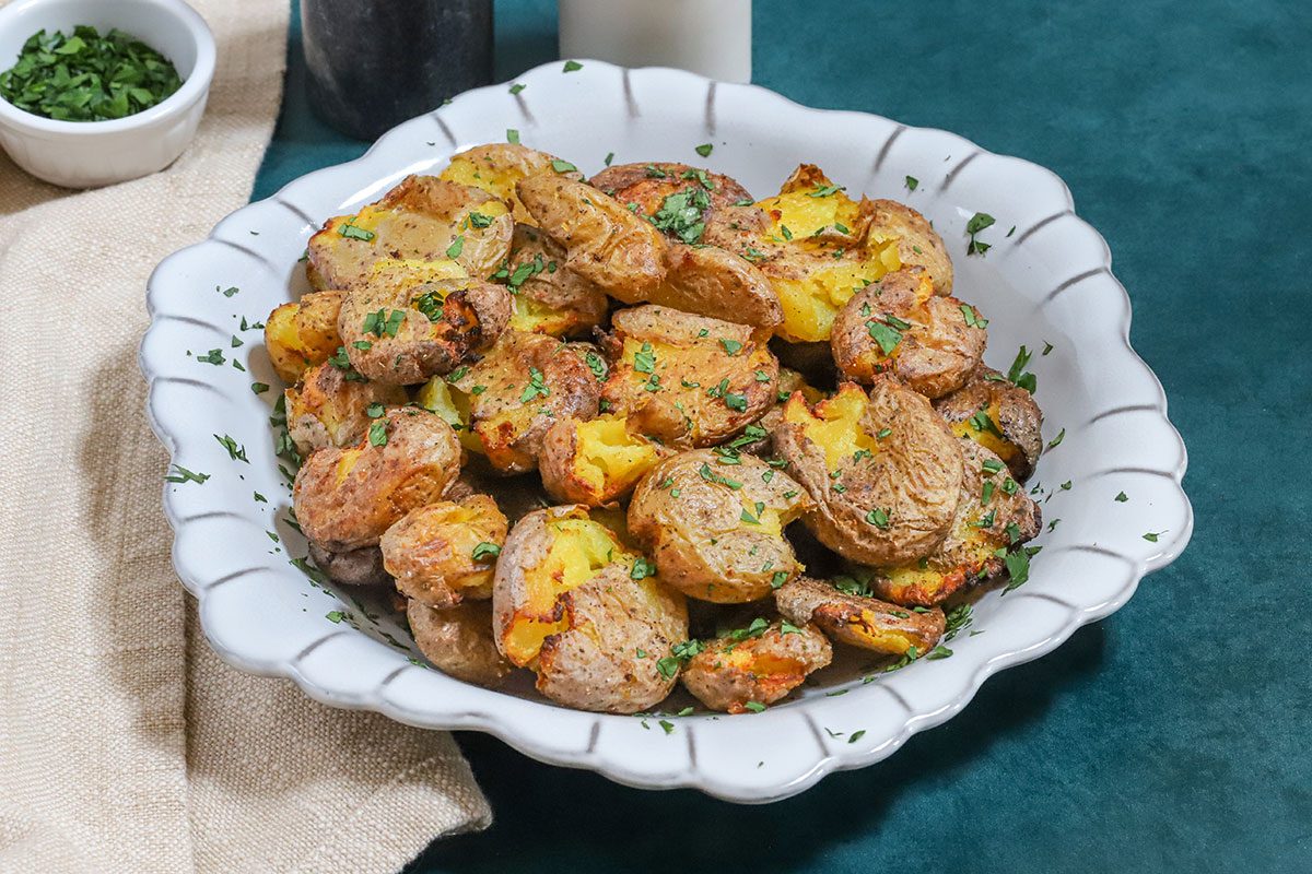 Air fryer smashed potatoes garnished with parsley.