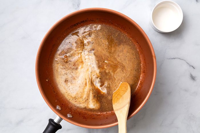 Cornstarch and water mixture added into apple cider sauce in large skillet for step three for Apple Cider Pork Chops recipe for Taste of Home