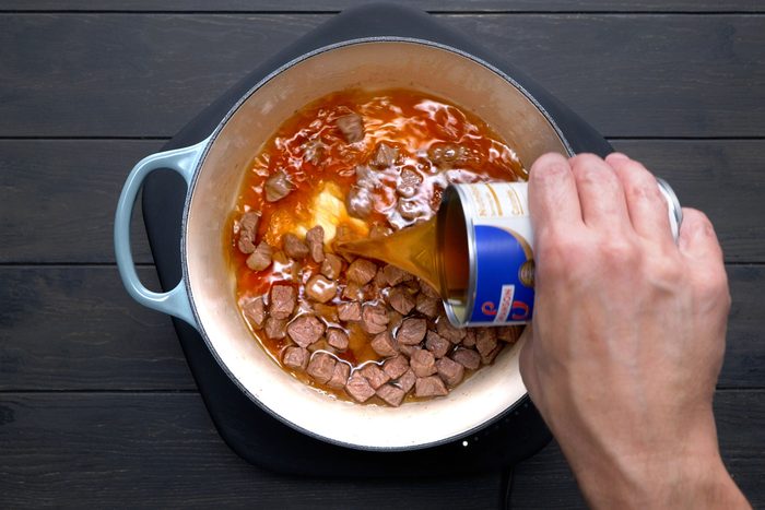 Pouring in broth, water, barley, salt and pepper