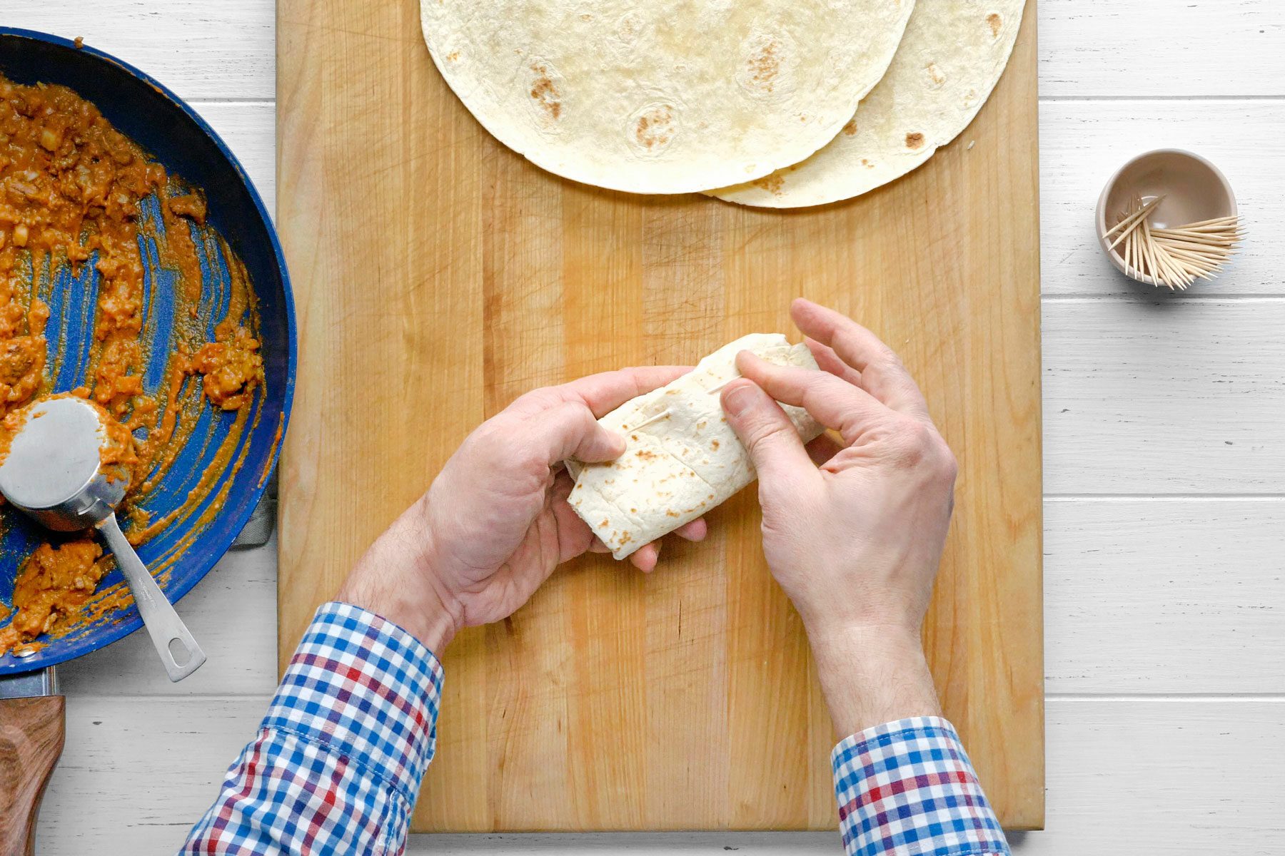 Folded tortilla being fastened with toothpick.