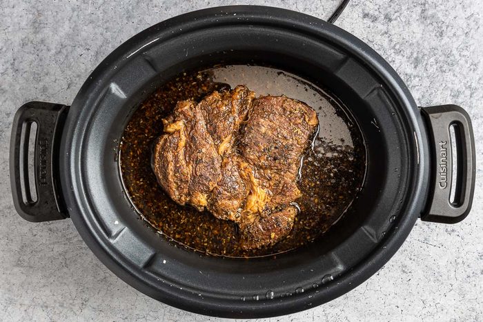 Taste of Home Beef with Polenta photo of the braised beef in a crock pot.