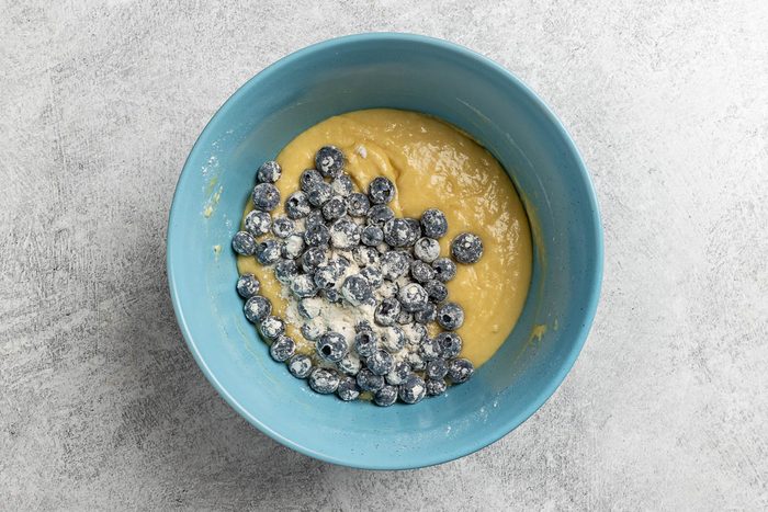 adding the blueberries to the batter.