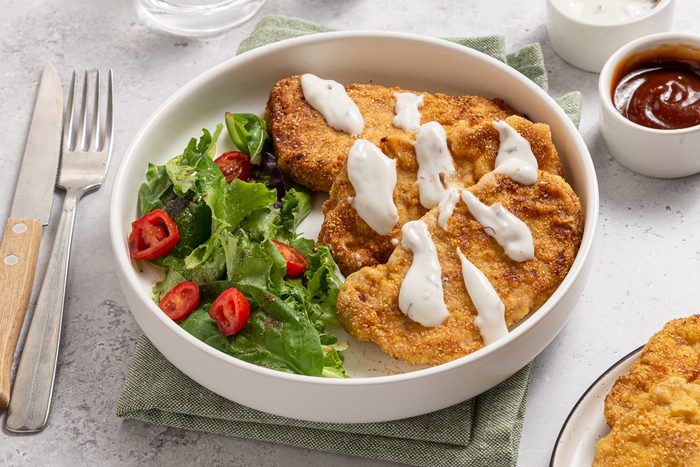 Breaded Pork Tenderloins And Green Salad With Ranch Sauce