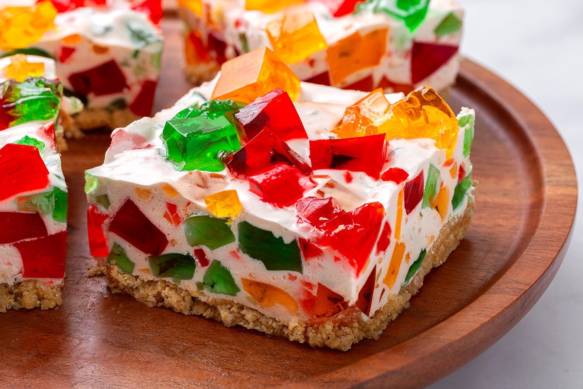 A slice of Broken Glass Jello of a wooden serving platter for Broken Glass Jello recipe for Taste of Home