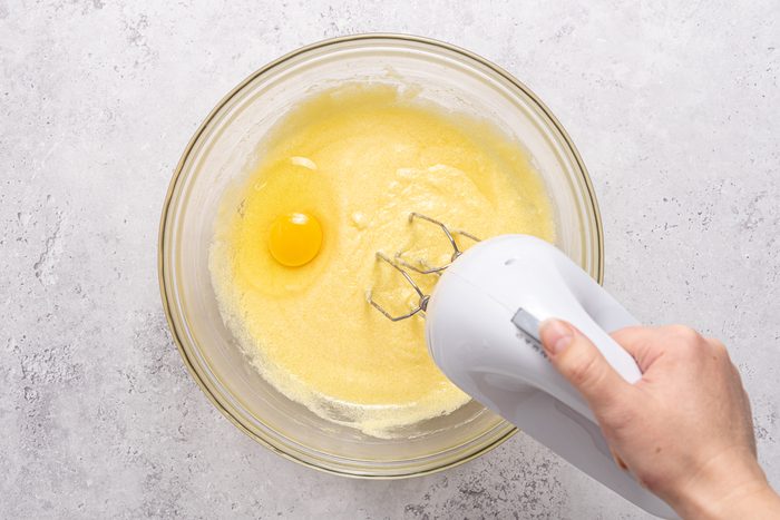 Hand Mixer In Bowl With Batter And Egg