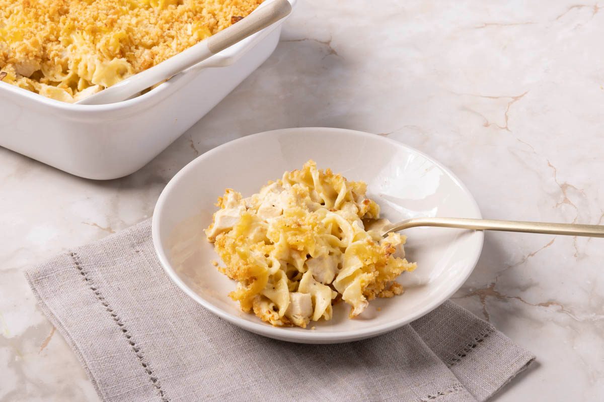 Close up of single serving of Chicken Noodle Casserole in a bowl 3/4 view on a marble table