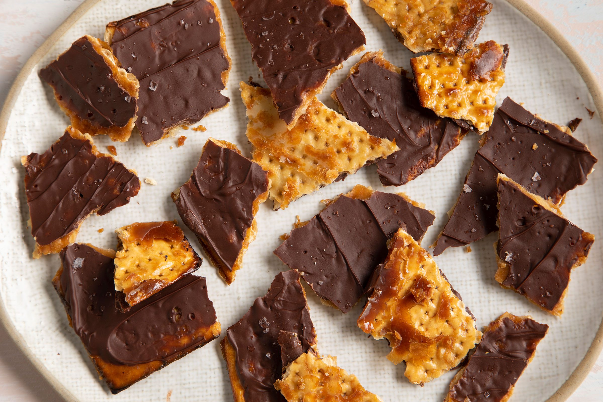 Chocolate covered Matzo in bits and pieces on a white plate