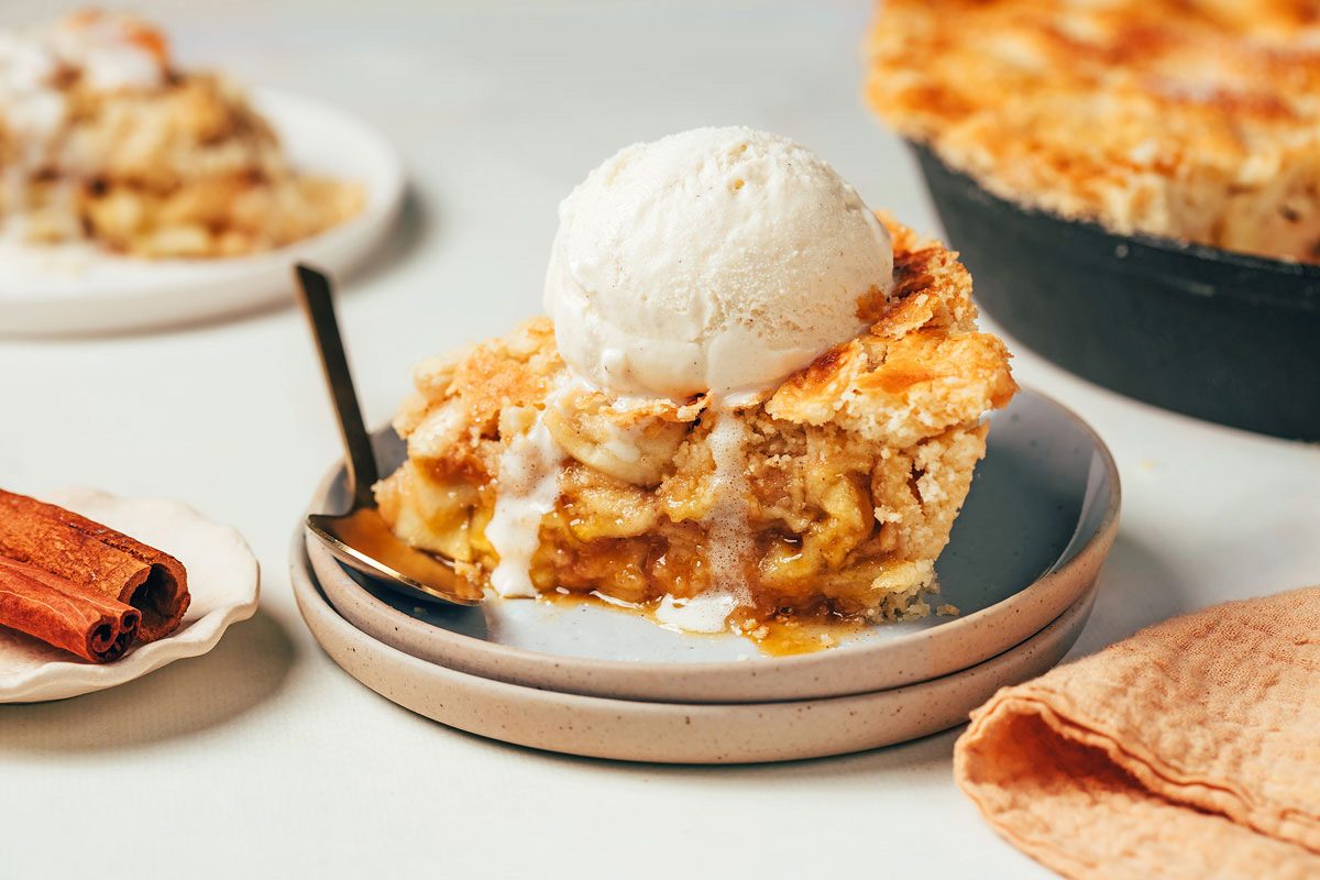 A slice of Cinnamon Apple Pie recipe by Taste of Home topped with melting ice cream