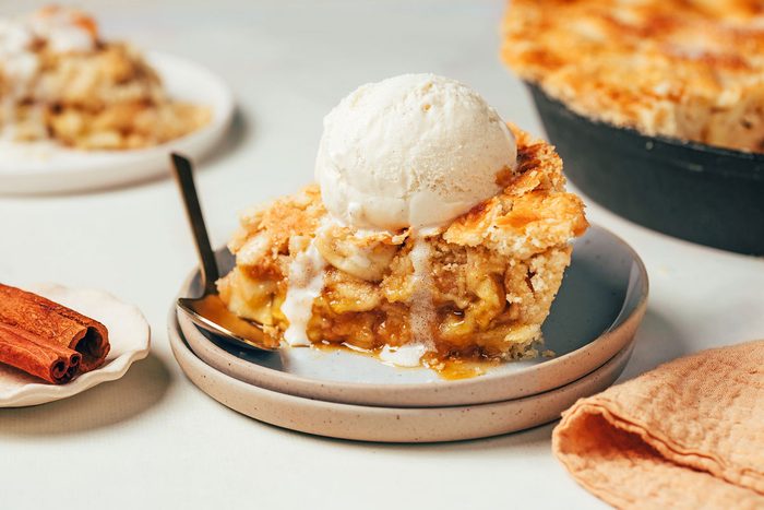 A slice of Cinnamon Apple Pie recipe by Taste of Home topped with melting ice cream
