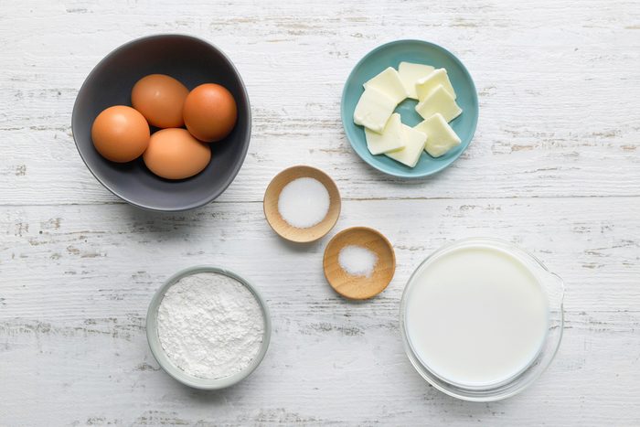 overhead shot crepes ingredients placed over white wooden background