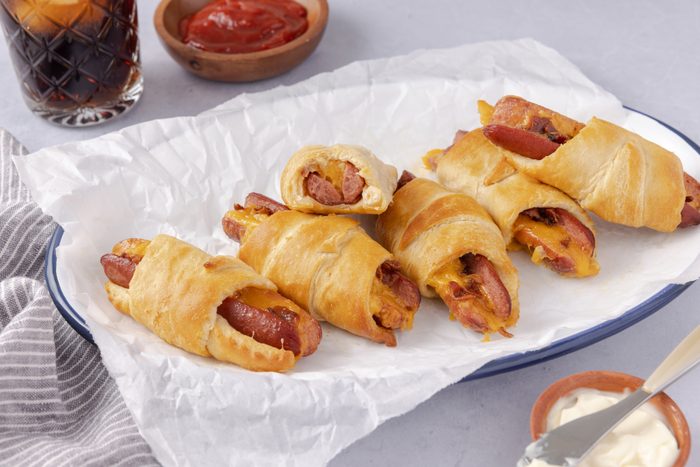 Crescent roll hot dogs baked and served on enamel plate.