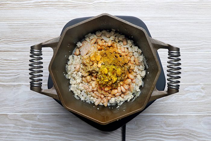 Stir mashed beans, remaining can of beans, chiles, seasonings and broth into chicken mixture