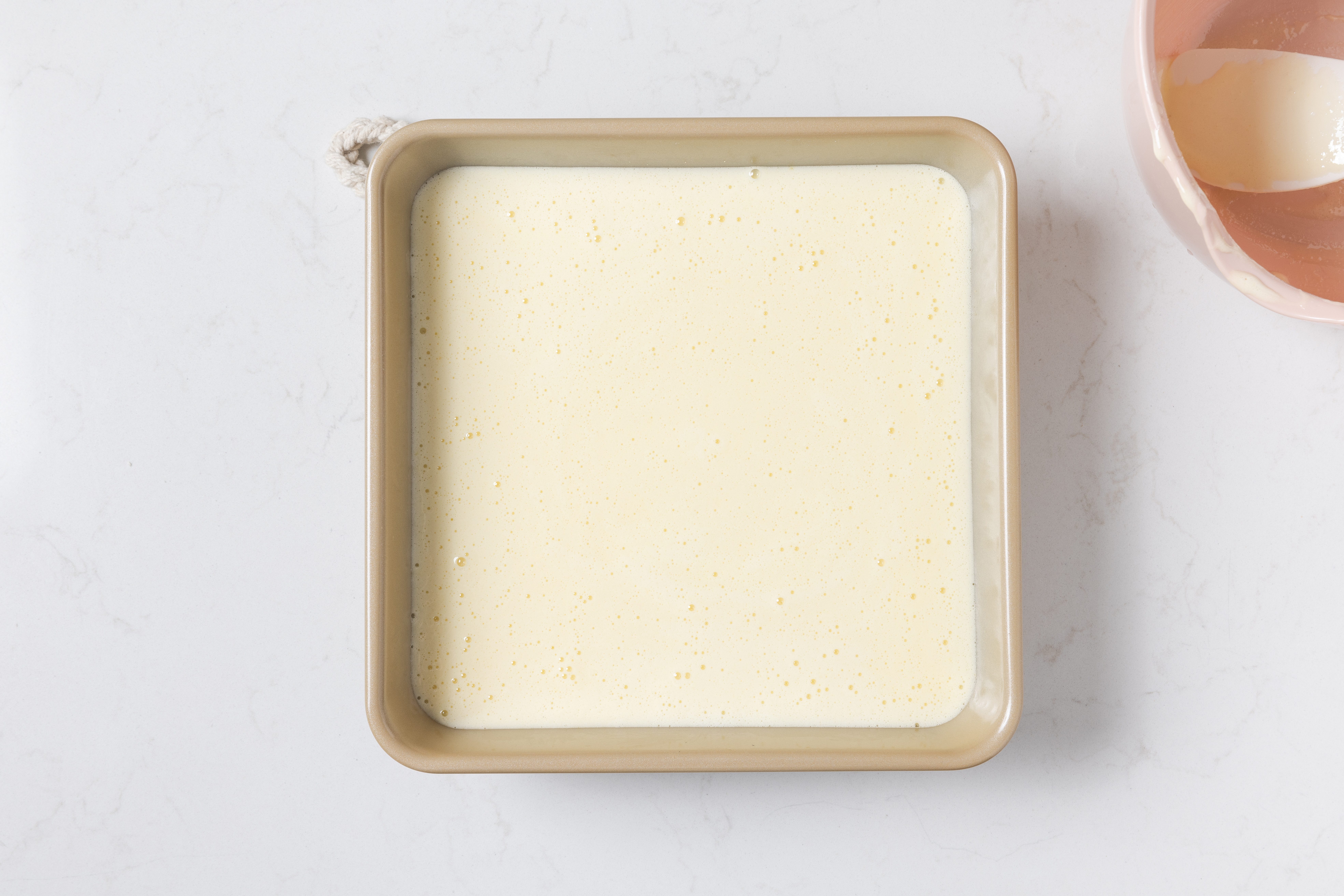 Lemon bars filling on top of baked base.