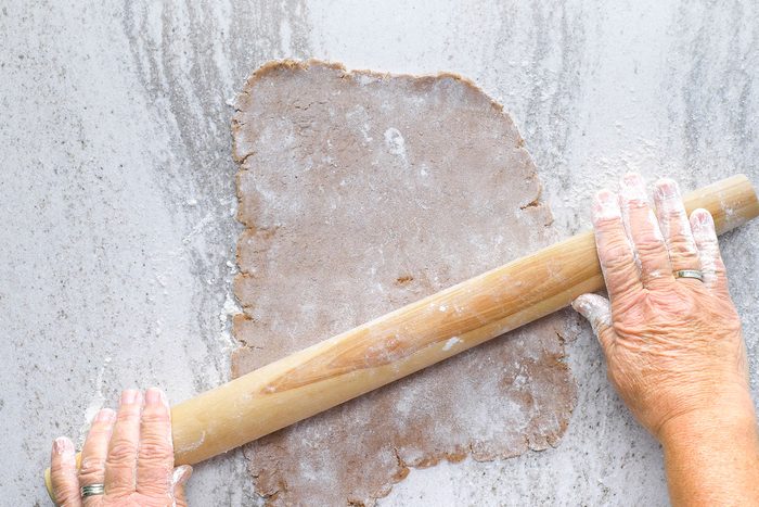Rolling out the dough with a rolling pin on a flat surface