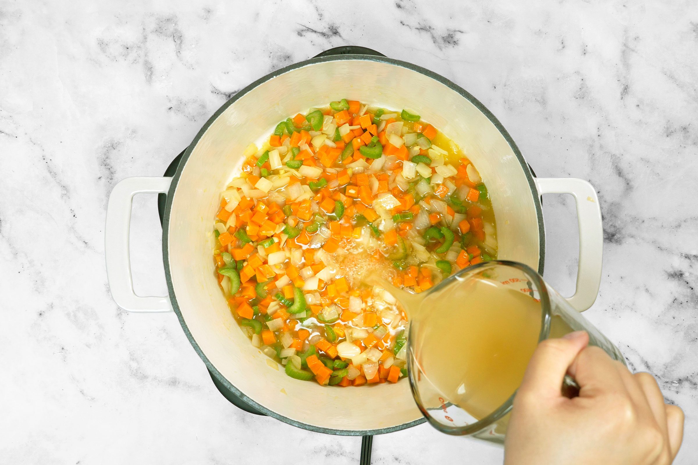 Adding broth in saute onion, carrot and celery 