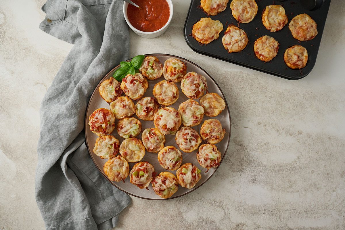 Overhead hero shot of the finished Taste of Home Pizza Bites, golden brown and topped with melted cheese, served on a plate and ready to enjoy.