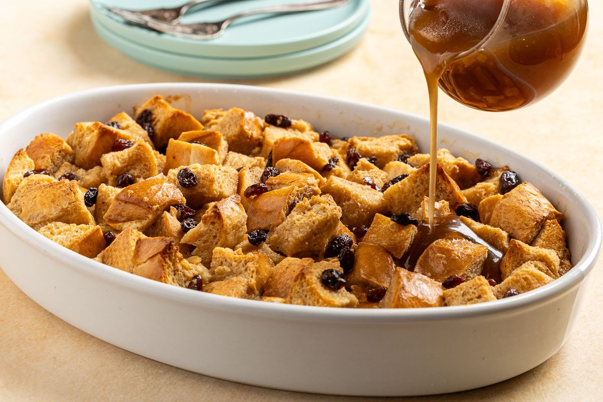 adding sauce onto New Orleans Bread Pudding