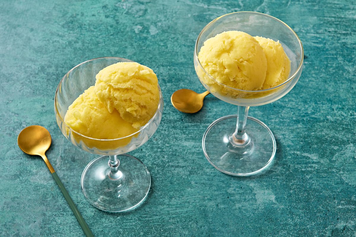 Two cocktail glasses filled with scoops of pineapple sherbet
