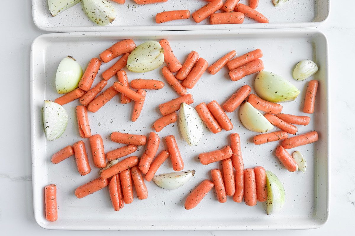 Taste of Home Roasted Carrots and Onions on white baking sheets