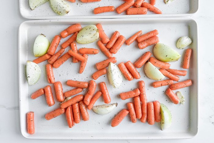 Taste of Home Roasted Carrots and Onions on white baking sheets