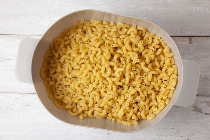 Step 1 of Taste of Home Sausage Mac and Cheese is to cook the macaroni according to the package's directions. Drain and set aside.