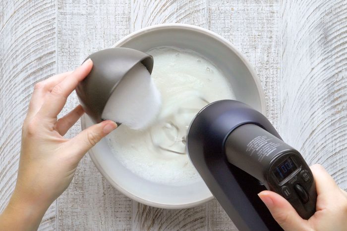 Egg whites, salt and sugar being mixed in a small bowl.