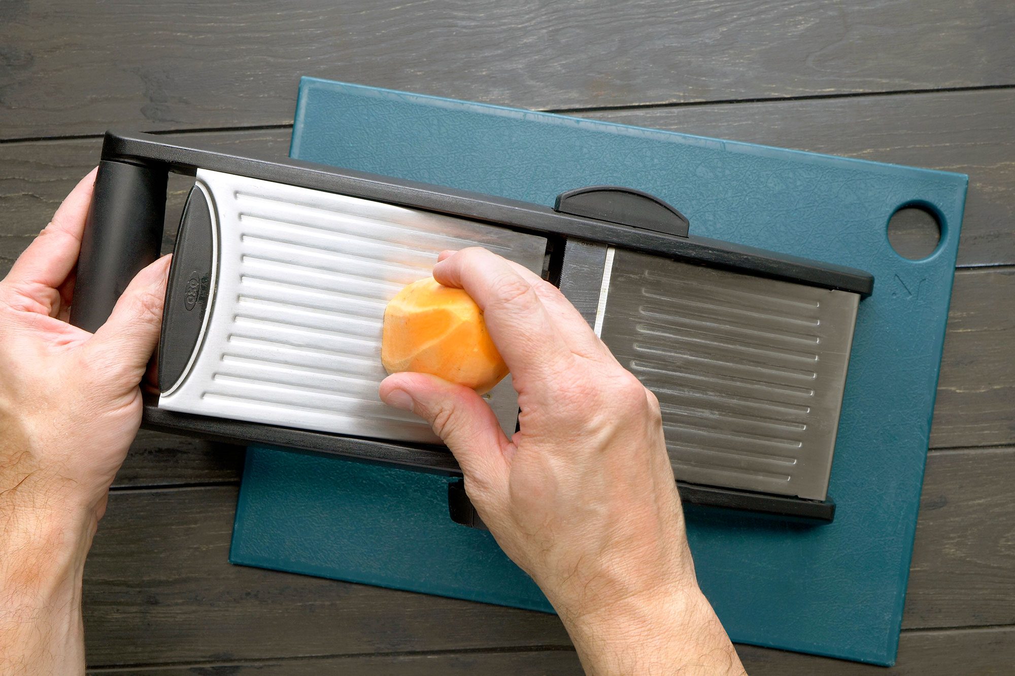 Using a vegetable slicer to shred a sweet potato